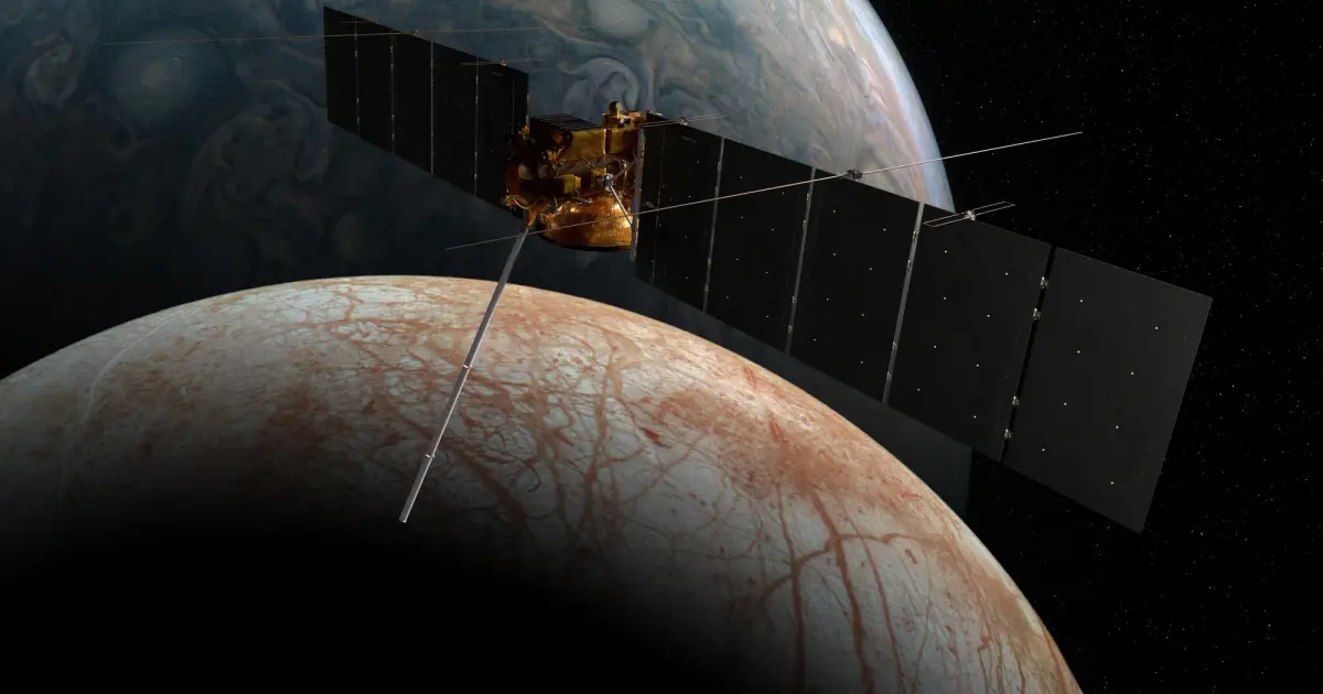 Το διαστημόπλοιο Europa Clipper της NASA σε καλλιτεχνική απεικόνιση μπροστά από το παγωμένο φεγγάρι Ευρώπη του Δία, με ανοιχτά ηλιακά πάνελ.
