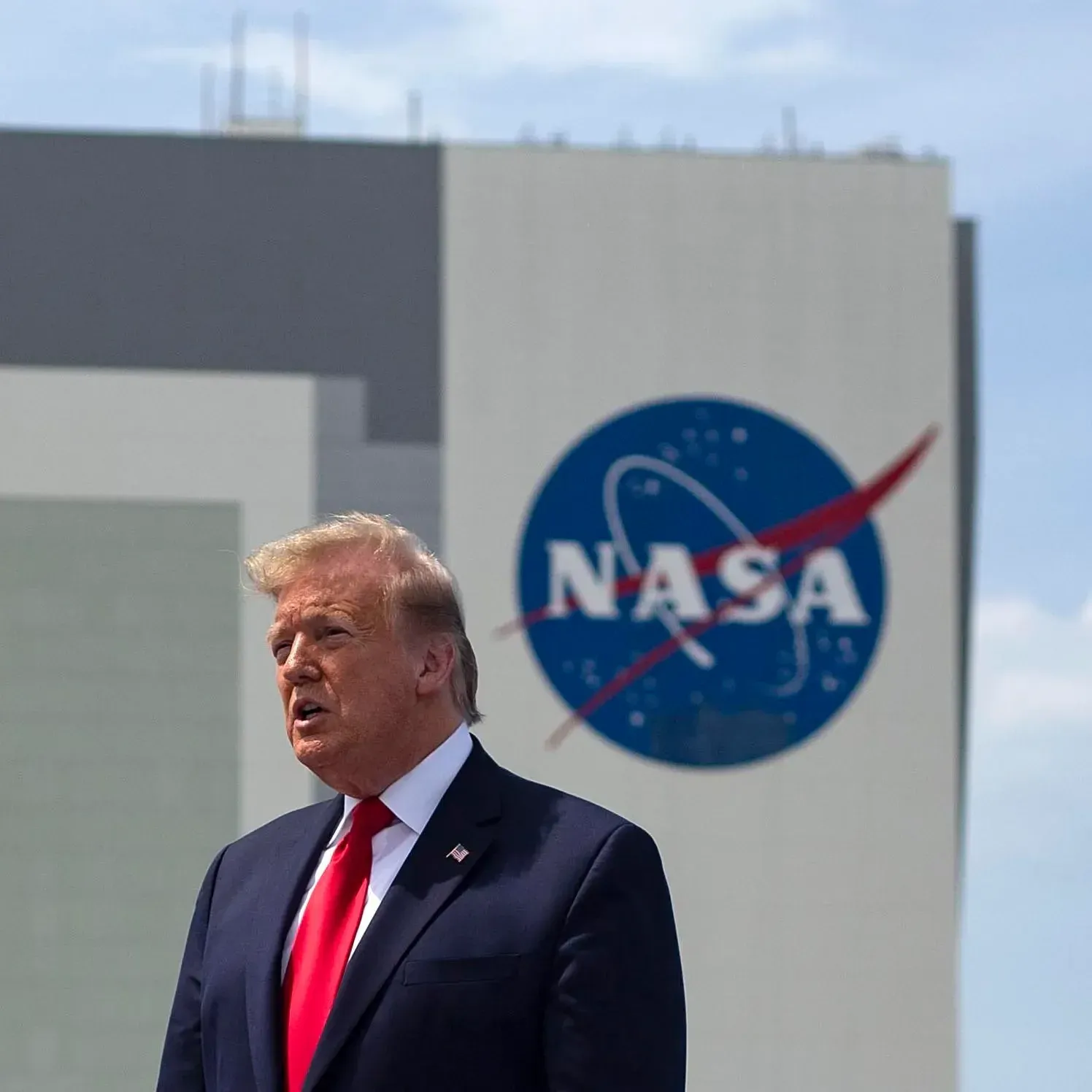 Ο Donald Trump μιλά μπροστά στο λογότυπο της NASA στο Κέντρο Kennedy, με φόντο τις περικοπές στον προϋπολογισμό της NASA